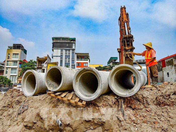 Công nhân chuẩn bị lắp đặt cấu kiện bê tông phục vụ thi công hệ thống thoát nước trên tuyến đường Vành đai 2,5 qua phường Xuân Đỉnh. Ảnh: Trung Nguyên - TTXVN 