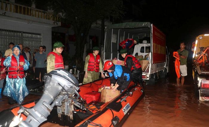 Các nhu yếu phẩm và các suất cơm được tập kết lên các xuồng để đem đến hỗ trợ bà con. Ảnh: Duy Chiến (ảnh chụp đêm 23/8).