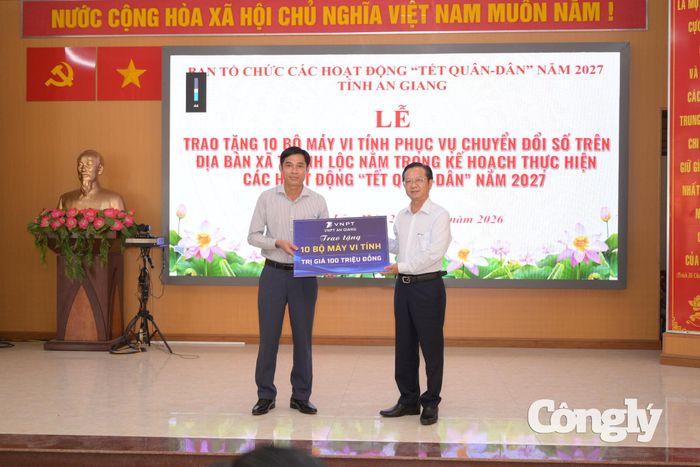 Ông Lữ Văn Cam, Phó Giám đốc VNPT An Giang, đại diện đơn vị tài trợ trao bảng tượng trưng bàn giao 10 bộ máy tính cho UBND xã Thạnh Lộc