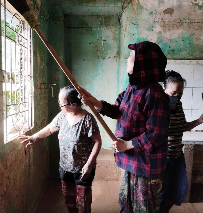  Người dân thôn An Châu, xã Sơn Động giúp hộ bà Thân Thị Lý dọn dẹp nhà sau lũ. 