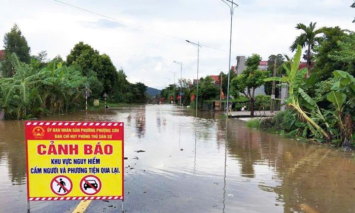 Lực lượng chức năng cắm biển cảnh báo khu vực nước sâu nguy hiểm cấm người và phương tiện qua lại trên quốc lộ 31 qua phường Phượng Sơn.