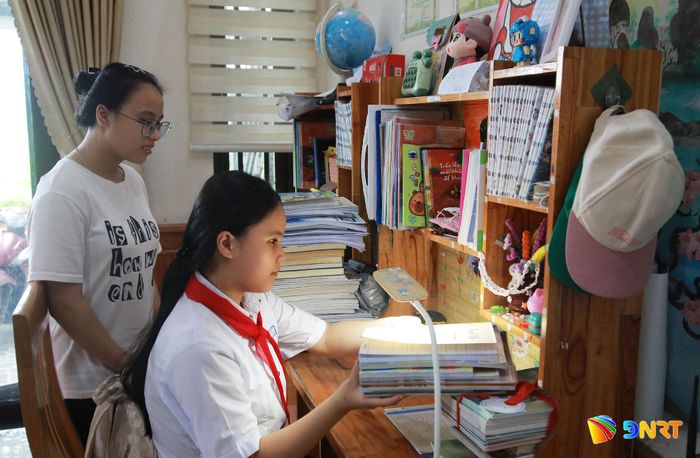 Em Phan Ngọc Kiều Ly và chị gái bên góc học tập tại nhà. Ảnh: ĐẮC MẠNH
