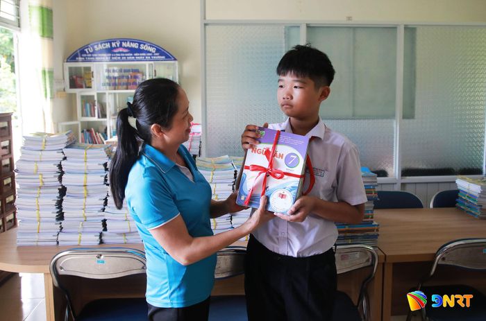 Em Tán Nguyễn Trí Nguyễn (học sinh lớp 7/4 Trường THCS Trần Quốc Tuấn) nhận bộ sách giáo khoa mới. Ảnh: ĐẮC MẠNH