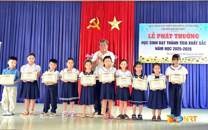 Thôn Hòa Đông tặng giấy khen và quà động viên các em học sinh lớp Một có thành tích xuất sắc trong năm học 2025 - 2026. Ảnh: KHẢI KHIÊM