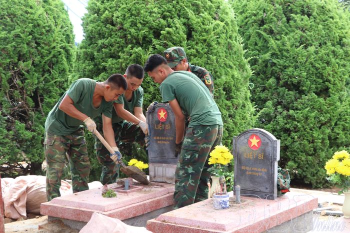 Cán bộ, chiến sĩ lực lượng vũ trang tỉnh cẩn trọng hoàn nguyên phần mộ sau khi lấy mẫu ADN tại Nghĩa trang Liệt sĩ Độc Lập.