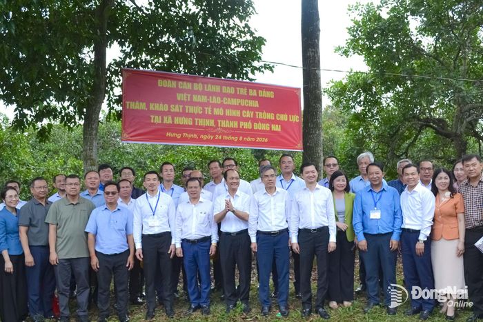 Các đại biểu chụp hình lưu niệm tại vườn ca cao xã Hưng Thịnh. Ảnh: Phương Hằng
