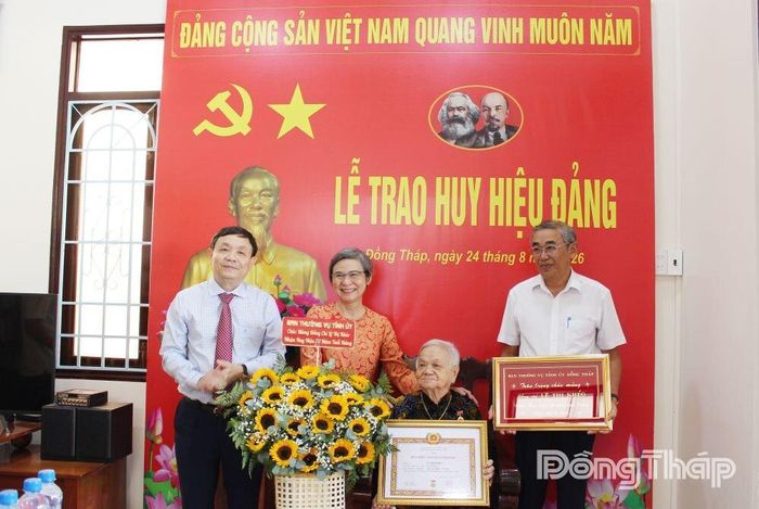 Đồng chí Phan Văn Thắng trao Huy hiệu 70 năm tuổi Đảng cho đảng viên Lê Thị Khéo.