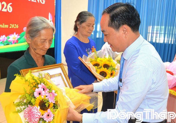 Đồng chí Nguyễn Kiên Cường trao hoa chúc mừng các đảng viên nhận Huy hiệu Đảng. 