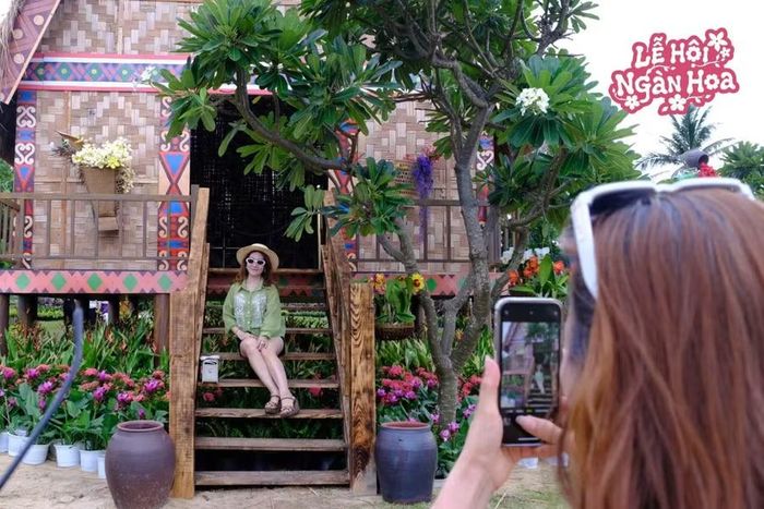 Du khách check-in tại tiểu mô hình nhà rông Tây Nguyên được bố trí tại lễ hội. Ảnh: FLC Quy Nhơn