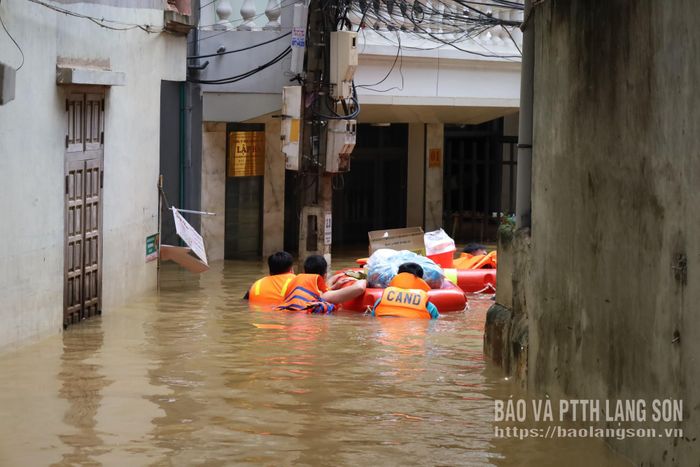 Các lực lượng chức năng hỗ trợ vận chuyển cơm đến các hộ ngập lụt 