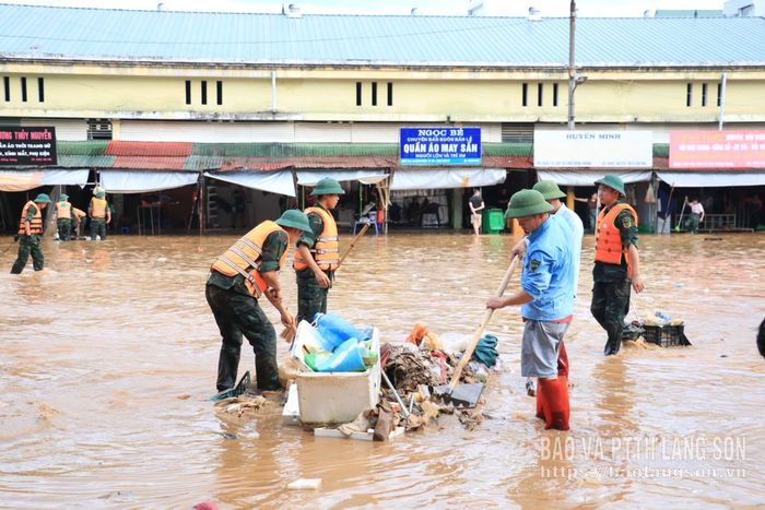 Các lực lượng cùng người người dân thu gom rác tại chợ Giếng Vuông