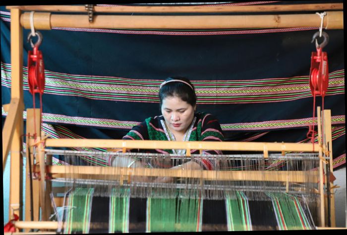 Chị H'Bình bên khung cửi, gìn giữ nghề dệt thổ cẩm truyền thống