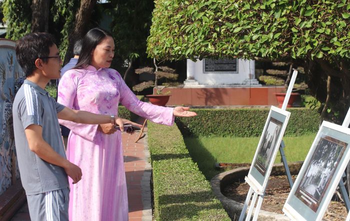 Khách tham quan đang được thuyết minh viên bảo tàng giới thiệu về hình ảnh trưng bày vào các dịp lễ, tết
