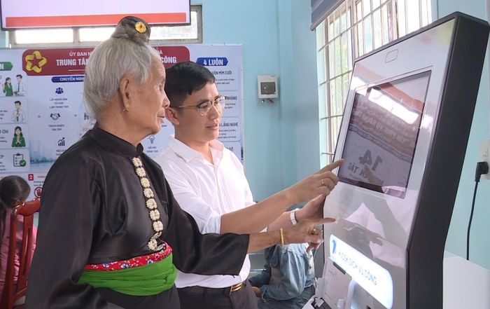 Công chức xã Phúc Thọ Lâm Hà hướng dẫn người dân sử dụng kiosk dịch vụ công
