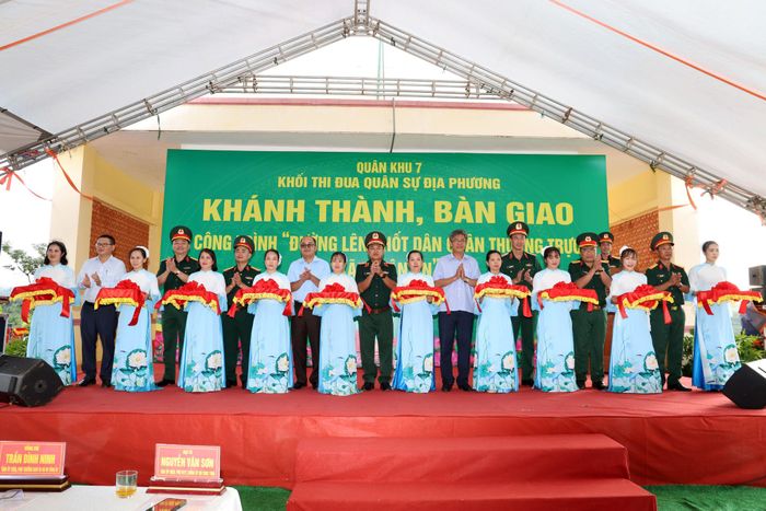 Các đại biểu thực hiện nghi thức cắt băng khánh thành Đường lên Chốt Dân quân thường trực xã Thuận An