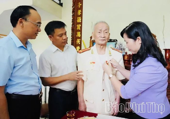 Đồng chí Bùi Thị Thu Hằng - Ủy viên Ban Thường vụ Tỉnh ủy, Chủ nhiệm Ủy ban Kiểm tra Tỉnh ủy trao Huy hiệu 70 năm tuổi Đảng tặng đồng chí Nguyễn Văn Chè.