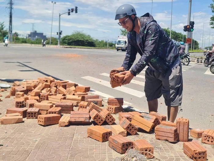 Anh Huỳnh Tấn Thượng chủ động thu gom số gạch bị rơi giữa ngã tư đường Nam Kỳ Khỏi Nghĩa và Mai Đăng Chơn