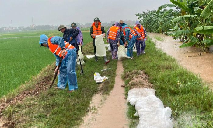 Hơn 100 cán bộ, chiến sĩ công an, bộ đội cùng nhân dân đắp đê bối, gia cố các vị trí xung yếu, phòng, chống tràn khu vực đê sông Lục Nam, đoạn qua thôn Ba Đọ, xã Lục Nam. Ảnh: Thành Văn