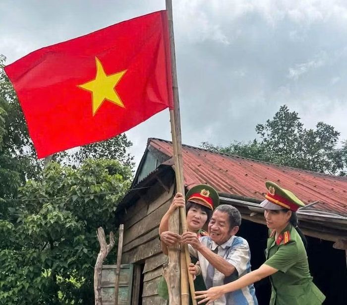 Niềm vui của bà con dân tộc thiểu số ở biên giới khi được các nữ cán bộ, chiến sĩ Công an tỉnh Quảng Trị tặng và hỗ trợ treo cờ chuẩn bị chào mừng lễ Quốc khánh 2/9.