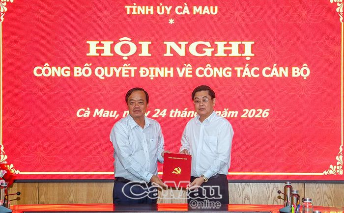 Đồng chí Huỳnh Quốc Việt, Phó Bí thư Thường trực Tỉnh uỷ (bên trái), trao Quyết định điều động của Ban Thường vụ Tỉnh uỷ đến đồng chí Phạm Minh Luyến.