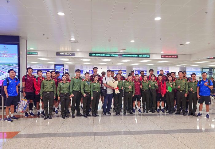 Các cầu thủ ĐT Việt Nam chụp ảnh cùng các nhân viên an ninh sân bay trong ngày trở về nước