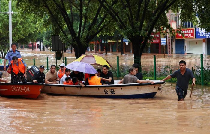 Nhân viên cứu hộ sơ tán người bị ảnh hưởng bởi lũ lụt do bão Narra gây ra. (Ảnh: Reuters)