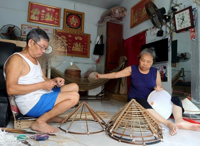 Vợ chồng ông Nguyễn Đăng Giáp ngày ngày miệt mài đan nón. Ảnh: Hoàng Quyết