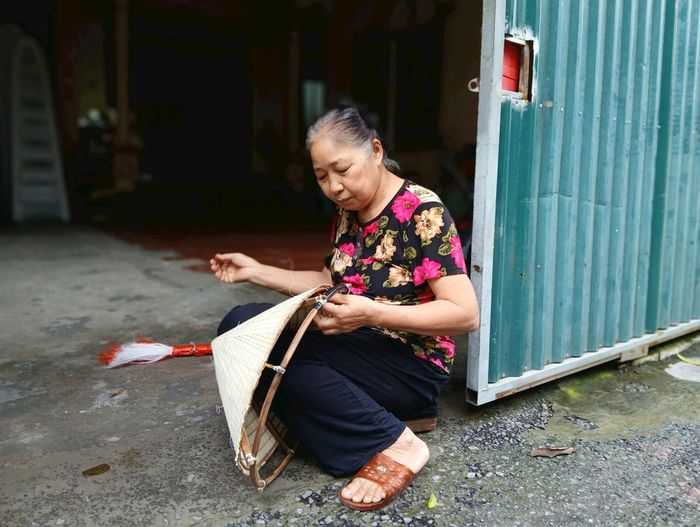 Bà Nguyễn Thị Lan đan nón. Ảnh: Hoàng Quyết