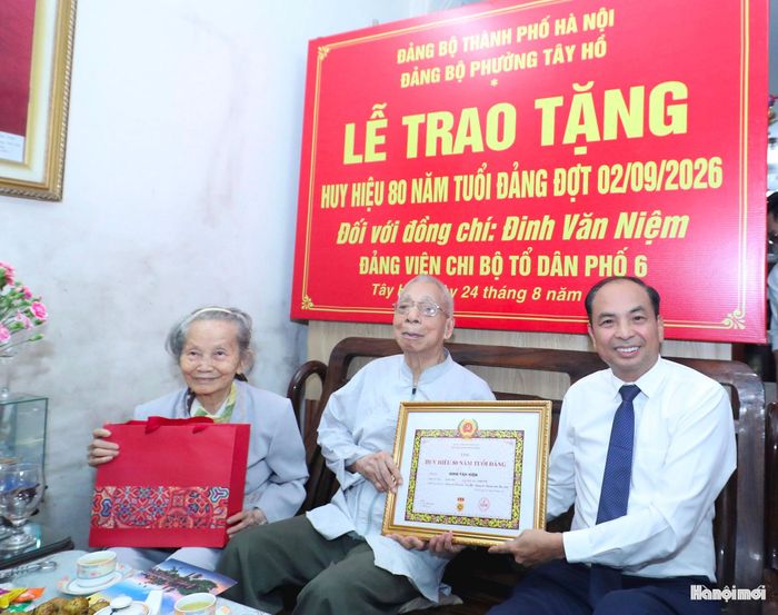 Bí thư Đảng ủy, Chủ tịch HĐND phường Tây Hồ Nguyễn Đình Khuyến trao Huy hiệu 80 năm tuổi Đảng tặng đảng viên Đinh Văn Niệm. Ảnh: Ngọc Tú