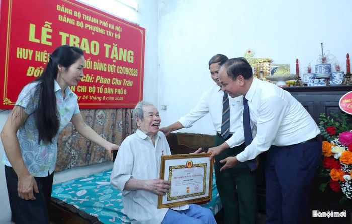 Bí thư Đảng uỷ phường Tây Hồ Nguyễn Đình Khuyến trao Huy hiệu 70 năm tuổi Đảng tặng đảng viên Phan Chu Trân. Ảnh: Ngọc Tú