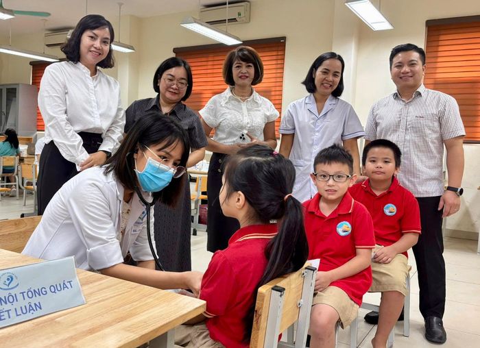 Lãnh đạo Trạm Y tế phường cùng Ban giám hiệu nhà trường theo dõi hoạt động khám sức khỏe định kỳ cho học sinh. Ảnh: Võ Giang