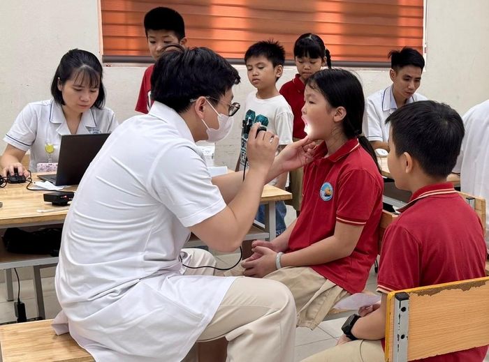 Bác sĩ khám tai, mũi, họng cho học sinh. Ảnh: Võ Giang