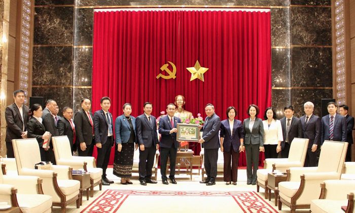 Phó Bí thư Thành ủy Hà Nội Nguyễn Văn Phong trao bức tranh tặng Đoàn đại biểu Ủy ban Mặt trận Lào. Ảnh: Lê Dung