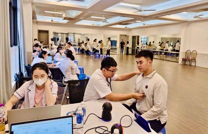 Các y, bác sĩ khám sức khoẻ cho học sinh phổ thông tại phường Phương Liệt. Ảnh: NO