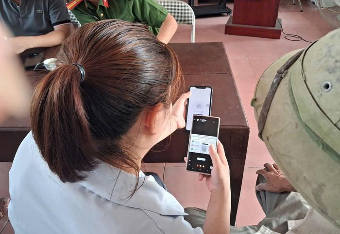 Thành viên các tổ chuyển đổi số tại xã Thuận An hướng dẫn người dân trong chuyển đổi số. Ảnh: Vân Thư