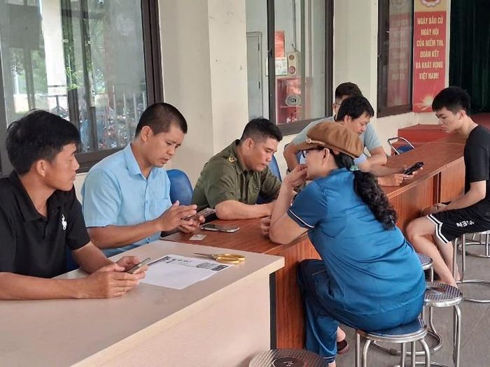 Công an xã, lực lượng an ninh cơ sở và các thành viên Tổ chuyển đổi số Tổ dân phố số 2 triển khai hướng dẫn người dân cài đặt ứng dụng báo cháy 114. Ảnh Vân Thư