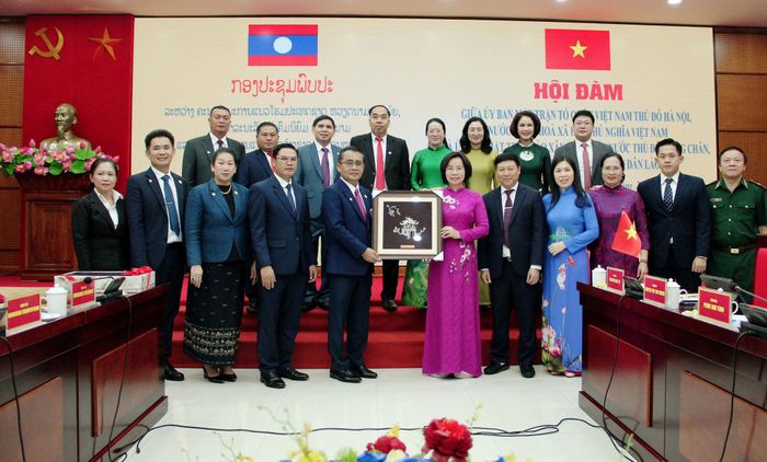 Ủy viên Ban Thường vụ Thành ủy, Chủ tịch Ủy ban MTTQ Việt Nam thành phố Hà Nội Bùi Huyền Mai trao quà lưu niệm tới Đoàn đại biểu Ủy ban Mặt trận Lào xây dựng đất nước Thủ đô Viêng Chăn. Ảnh: Lê Dung