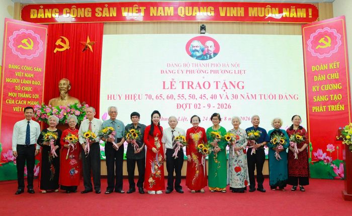Đại diện lãnh đạo phường Phương Liệt trao Huy hiệu Đảng tặng các đảng viên. Ảnh: HL