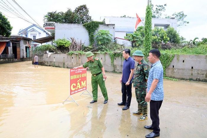 Chủ tịch UBND xã Xuân Mai Nguyễn Anh Đức kiểm tra, chỉ đạo lực lượng chức năng cắm biển cảnh báo người và phương tiện không đi vào khu vực ngập sâu. Ảnh: Hoàng Tình
