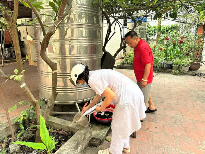 Cán bộ y tế xã Ô Diên kiểm tra các dụng cụ chứa nước tại hộ gia đình, hướng dẫn người dân loại bỏ nơi muỗi sinh sản, chủ động phòng, chống sốt xuất huyết. Ảnh: Đỗ Duẩn