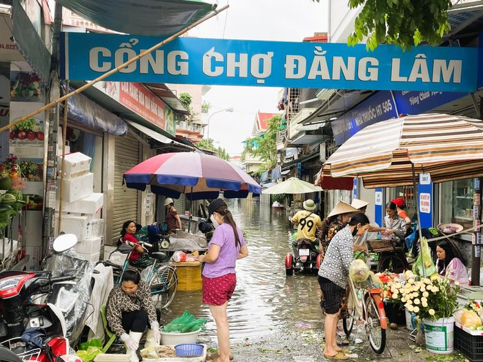 Chợ Đằng Lâm chỉ hoạt động một phần phía đường cao; bên trong lụt sâu không thể bán hàng. Ảnh: TD