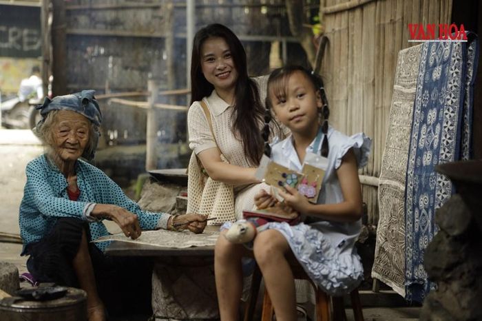 Nhiều du khách tìm đến chiêm ngưỡng quy trình vẽ sáp ong và chụp ảnh cùng người nghệ nhân gần trăm năm tuổi