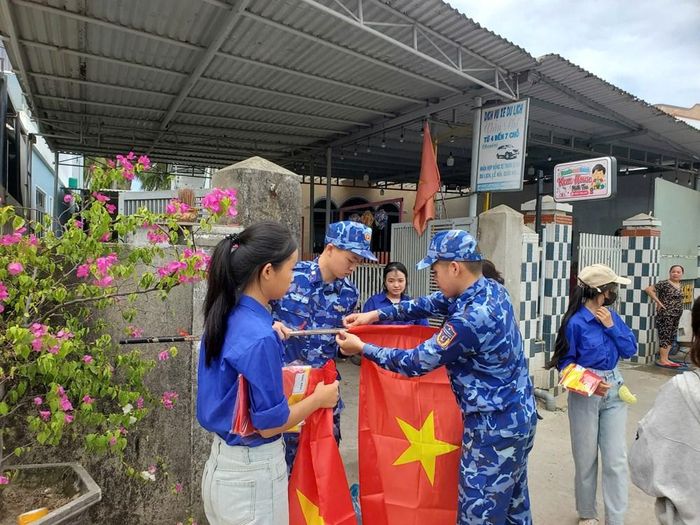 Các chiến sĩ và đoàn viên thôn cùng treo cờ Tổ quốc