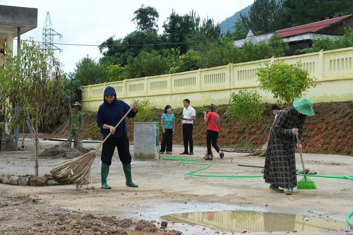 Các phụ huynh hỗ trợ giáo viên để cùng dọn dẹp, vệ sinh khuôn viên trường lớp, sẵn sàng đón trẻ đến trường. Ảnh: Việt Dũng - TTXVN