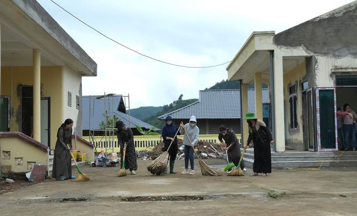 Các cô giáo cặm cụi dọn trường lớp, cùng chung quyết tâm “cho những bước chân trẻ thơ trở lại trường”. Ảnh: Việt Dũng - TTXVN