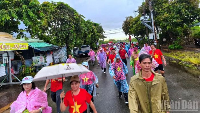 Người dân vùng nội thị Cà Mau mặc áo mưa đi bộ hưởng ứng Chương trình "Cùng Việt Nam tiến bước" năm 2025. (Ảnh: HỮU TÙNG)