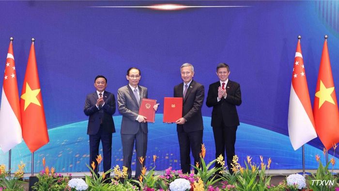 Ủy viên Bộ Chính trị, Bộ trưởng Ngoại giao Lê Hoài Trung và Bộ trưởng Ngoại giao Singapore Vivian Balakrishnan trao Bản ghi nhớ hợp tác giữa hai Đảng. (Ảnh: Phương Hoa/TTXVN)