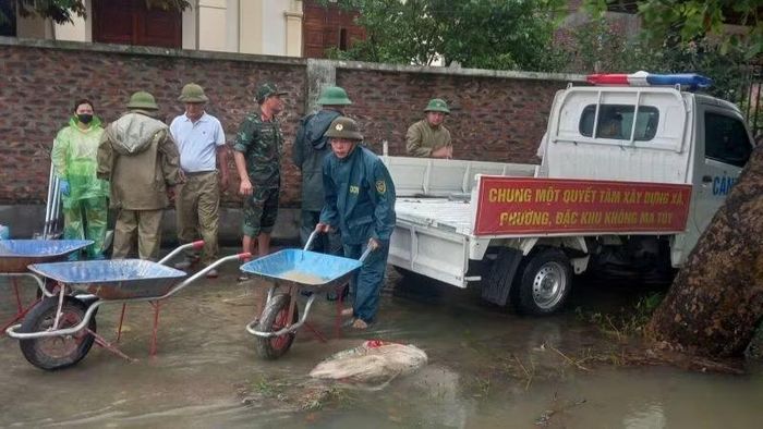 Lực lượng quân đội giúp người dân di chuyển tài sản trong lũ. (Ảnh: ĐG)
