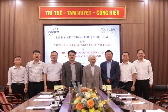 Giáo sư Trần Thanh Vân chụp ảnh lưu niệm cùng các nhà khoa học Viện Năng lượng nguyên tử Việt Nam. (Ảnh: THANH QUÝ)