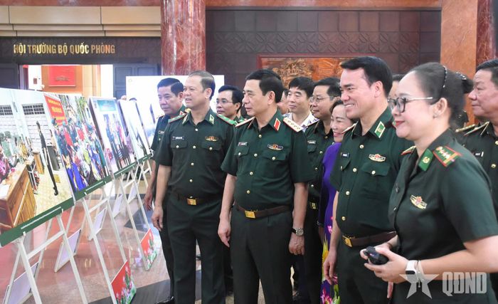 Đại tướng Phan Văn Giang và các đại biểu tham quan triển lãm ảnh tại hội nghị.
